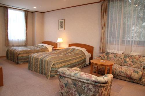 神户有馬 瑞宝園的酒店客房,设有两张床和一张沙发