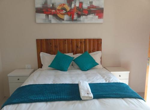 FosoMatholeng Gardens Guesthouse的一间卧室配有一张带蓝色枕头的床