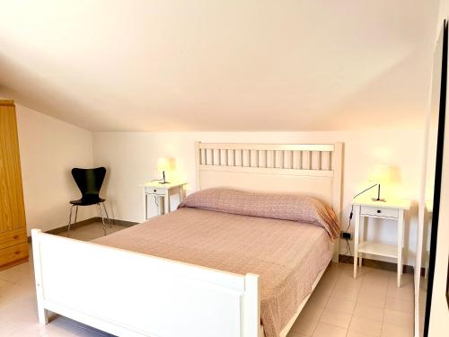 Leporano MarinaVilletta Sofia的一间卧室配有床和两张桌子及椅子