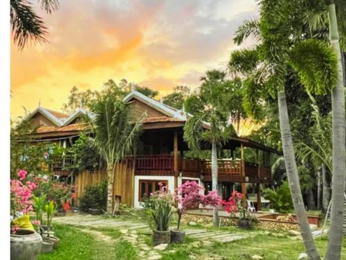 贡布Devi Kampot Resort at Phum Kampot的前面有棕榈树的房子