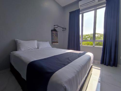加央Lembah Saerah Resort的一间卧室配有一张带蓝色窗帘的床和一扇窗户