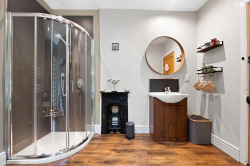 马特洛克Wellington - Matlock的带淋浴、盥洗盆和镜子的浴室