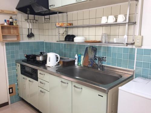 高松INARI - Vacation STAY 87349的厨房配有不锈钢水槽和蓝色瓷砖