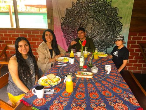 马尔多纳多港Aroldo Amazon Lodge的一群人坐在桌子旁吃着食物