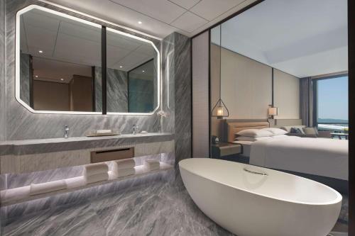 杭州杭州萧山国际机场凯悦酒店的带浴缸的浴室和1间带1张床的卧室