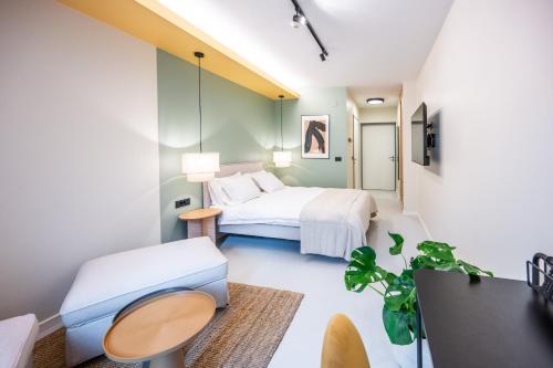 萨格勒布Superb Petrova Street Rooms的一间卧室配有一张床、一张桌子和一张沙发