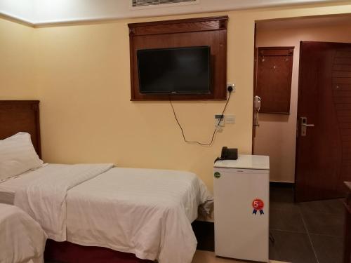 麦加جوار البيت مكة的酒店客房设有两张床和一台平面电视。