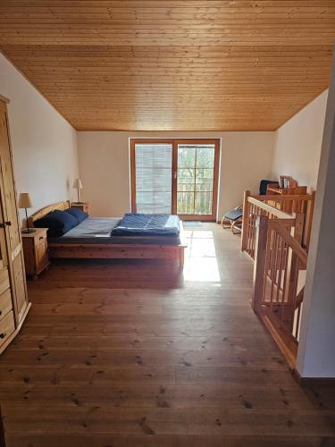 SimonsbergFerienwohnungen Das Finkhaus的一间设有一张床铺的卧室,位于一个拥有木制天花板的房间