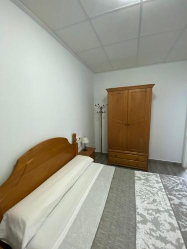 穆拉Apartamento Gabarron的一间卧室配有一张大床和一个木制橱柜
