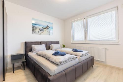 布拉迪斯拉发BNB Slovakia Ovocné sady Airport Apartment的一间卧室配有一张大床,上面有蓝色的毛巾