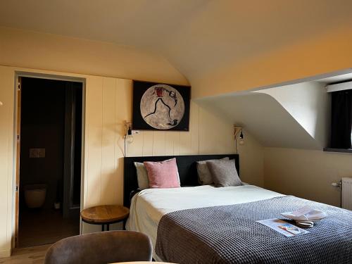 鲁汶Good night Leuven -Self check-in的卧室配有一张床,墙上挂着一个钟