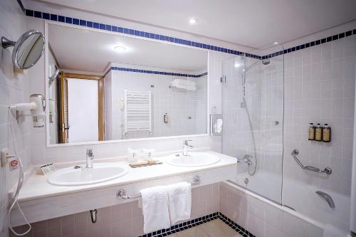 莫哈卡尔莫哈卡尔旅馆的白色的浴室设有水槽和淋浴。