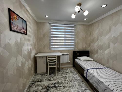 努库斯Entire Apartment in Central Nukus的一间卧室配有两张床、一张桌子和一张桌子