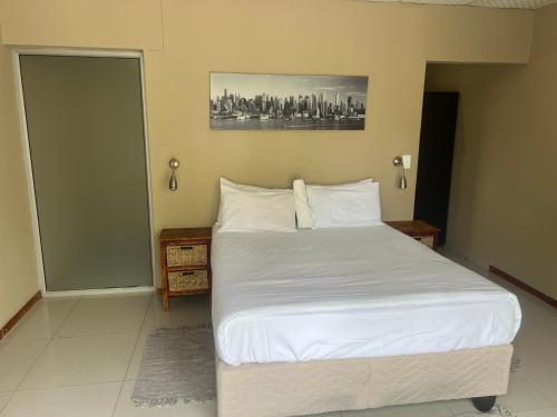 温当瓦Ondangwa Rest Camp的一间卧室配有一张带白色床单的大床