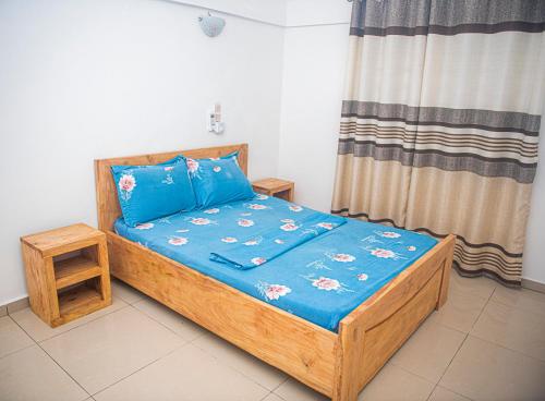 科托努Magnifique Maison de ville Bord de mer Cotonou Fidrjossè的一间小卧室,配有一张带蓝色床单的木床