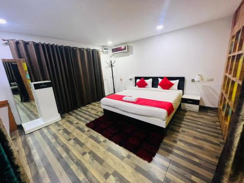 古瓦哈提PuHoR Hotel Plaza Inn的一间卧室配有一张带红色枕头的大床