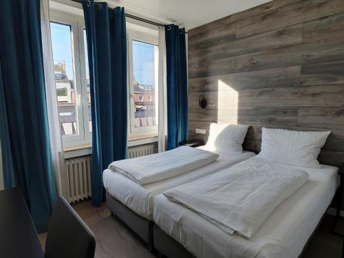 杜塞尔多夫Rheinmetropole Hotel的一间卧室设有一张大床和两个窗户。