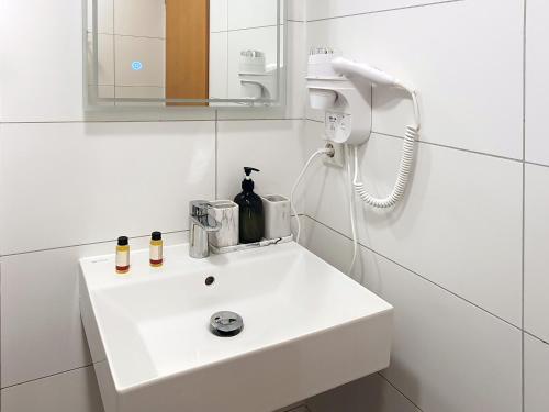 杜塞尔多夫Rheinmetropole Hotel的浴室设有白色水槽和镜子