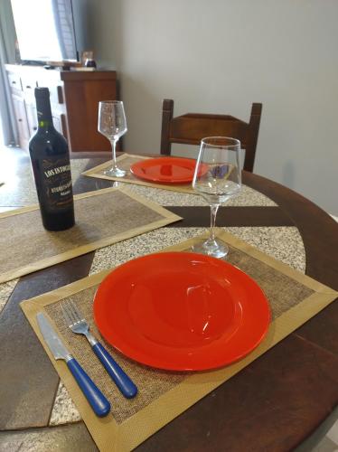 卢汉德库约Montaña Sol Malbec的一张带橙色盘子的桌子和一瓶葡萄酒