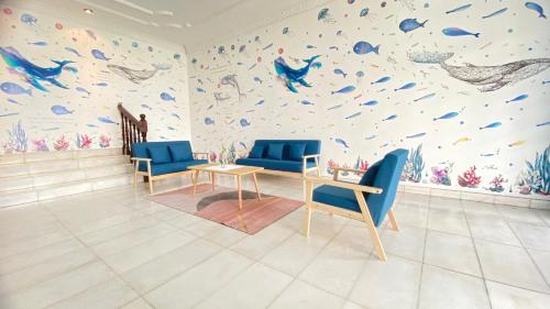 八打灵再也吉隆坡疯鱼民宿Crazy Fish Homestay KL的一间设有蓝色椅子和鱼墙的房间