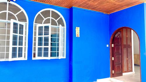 八打灵再也吉隆坡疯鱼民宿Crazy Fish Homestay KL的一面带两个窗户的蓝色墙壁和红色的门
