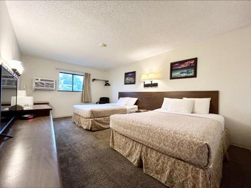 沃尔夫波因特Homestead Inn的酒店客房设有两张床和一台平面电视。