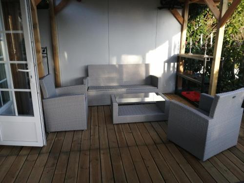 韦扎克CHALET LOU PADER的露台配有藤椅和甲板上的桌子