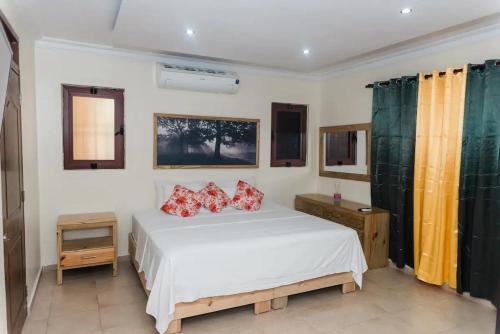 圣地亚哥洛斯卡巴Verde Bonavita的卧室配有带红色枕头的白色床