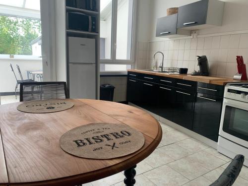 GuiseGITE Le tapis vert - Guise的厨房配有木桌和标志