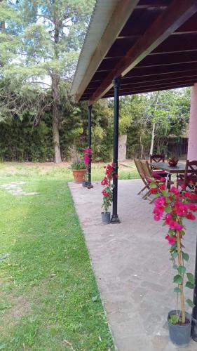 开门La Colorada, home for... La Amistad Polo的公园内种有桌子和鲜花的庭院