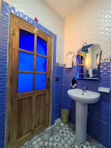 舍夫沙万Casa Blue Star的一间带木门和水槽的浴室