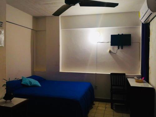阿卡普尔科Hotel zócalo abuelos的一间卧室配有蓝色的床和一张书桌