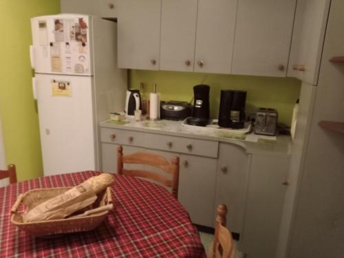 皮耶尔拉特Chambre chez l'habitant的厨房配有桌子、冰箱和带桌布的桌子