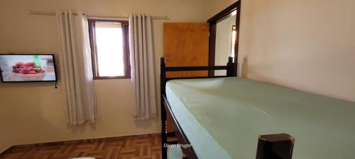 伊瓜苏Casa perto das Cataratas Seu lar para quatro的一间小卧室,配有床和窗户