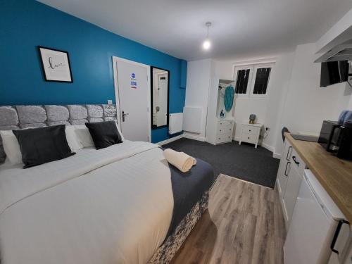 诺丁汉Nottingham Forest Rd, Short Stays的一间卧室设有一张大床和蓝色的墙壁