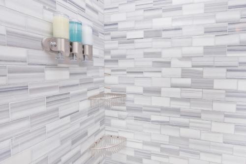 纽约Three Bedroom West Village Townhouse的浴室的墙壁上铺有白色和灰色瓷砖。