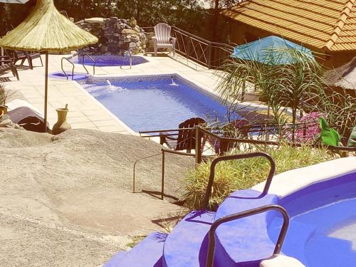 维拉卡洛斯帕兹Cabañas Layken的一个带椅子和遮阳伞的小型游泳池