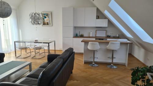 维也纳TOP Apartments Kaiserebersdorf的厨房以及带沙发和桌子的客厅。