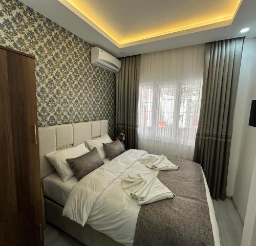 伊斯坦布尔Pera Apart的卧室在窗户前配有一张白色大床