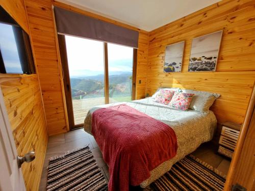 瓦尔帕莱索Mini casa en lo alto de la montaña的一间卧室设有一张床和一个大窗户