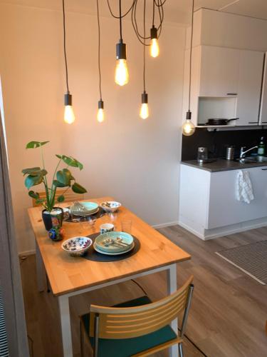 赫尔辛基Spacious Apartment Next to Metro, Beach, Shopping Centre的用餐室配有桌椅和灯