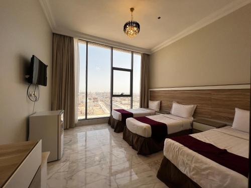 麦地那Taiba Karim Hotel Madina的酒店客房设有两张床和大窗户。
