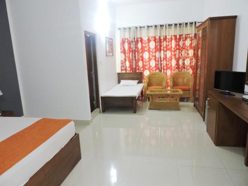 康提Hotel Travellers Nest Kandy的一间酒店客房,配有一张床和一台电视