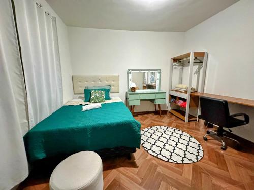 贝洛奥里藏特Espaço Nill的一间卧室配有一张绿色的床和一张书桌