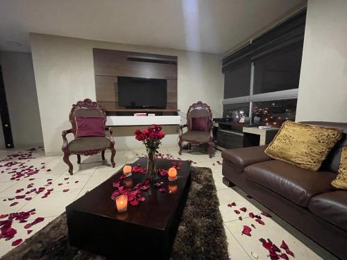 瓜亚基尔Five Stars Suites - Kennedy - Guayaquil的客厅配有沙发和鲜花桌