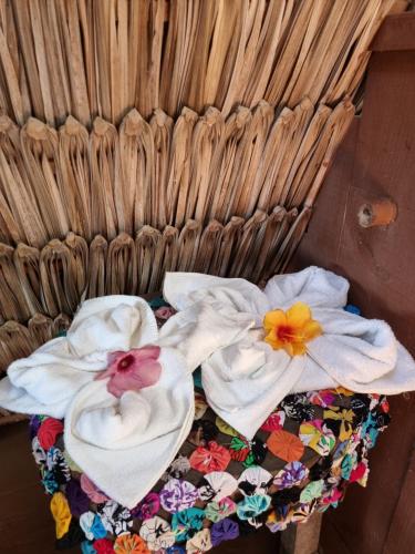 AmontadaEcocamping Lumiar的两条毛巾,篮子上放着鲜花