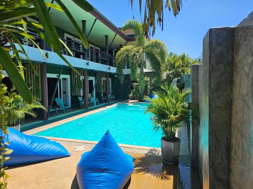 高兰Cha-Cha Hotel的房屋前的带蓝色枕头的游泳池