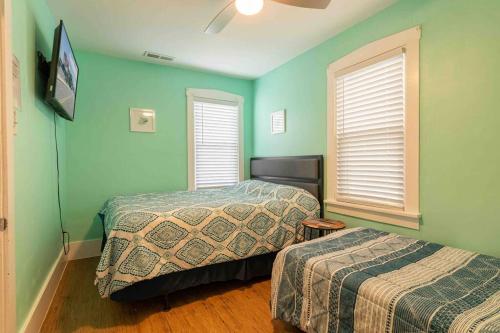 怀尔德伍德The Beach House - 6 Bedrooms - Beach / Boardwalk的配有两张床铺的绿色墙壁和窗户