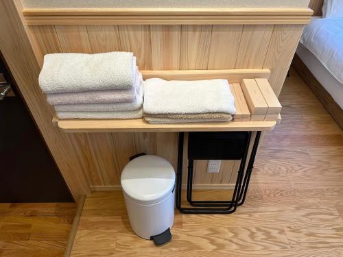 桑名市machiyado Kuwanajuku Edomachi 21的一间带卫生间和架子毛巾的浴室