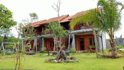 吉仙Sunny Eco Lodge的前面有棕榈树的房子